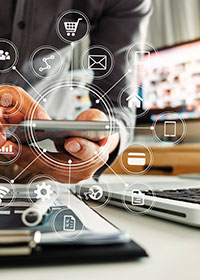 Matkapuhelin, läppäri ja lehti.