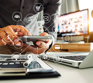 Matkapuhelin, läppäri ja lehti.